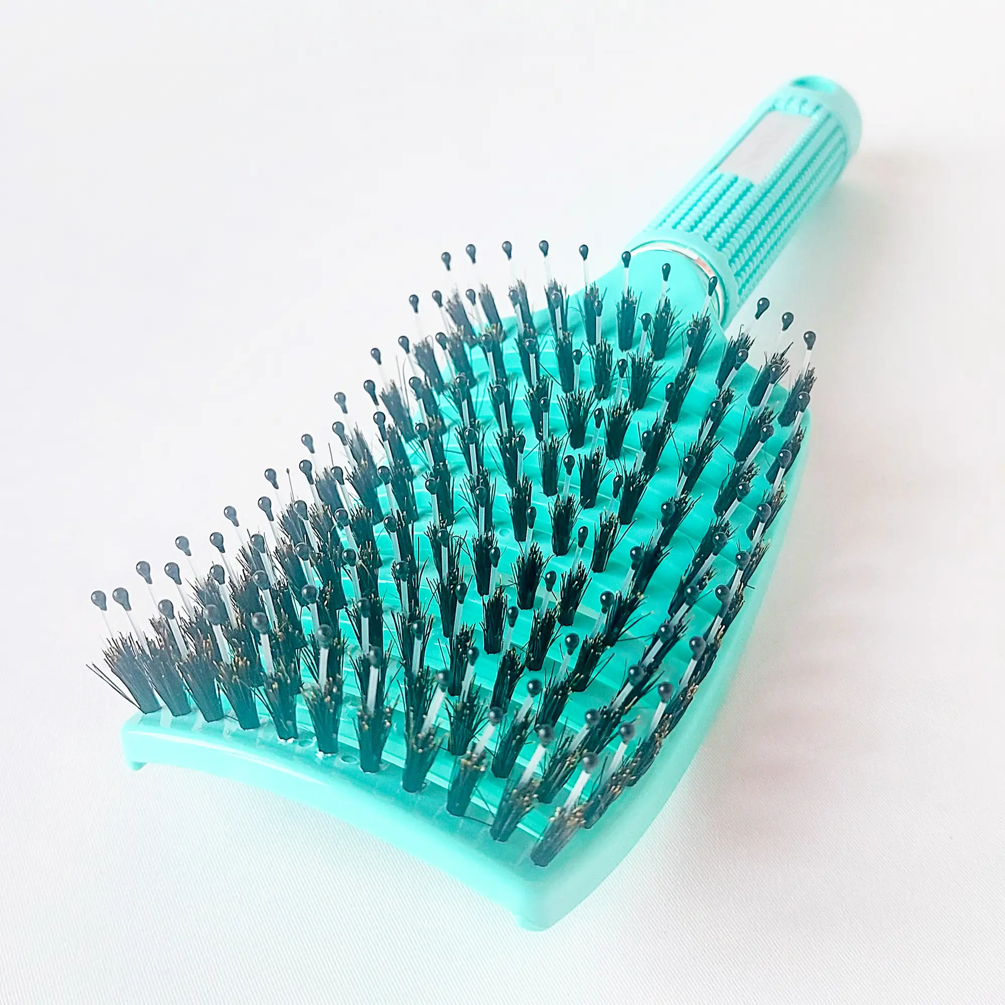 DreamGlow Anti-klit Haarborstel in teal op neutrale achtergrond
