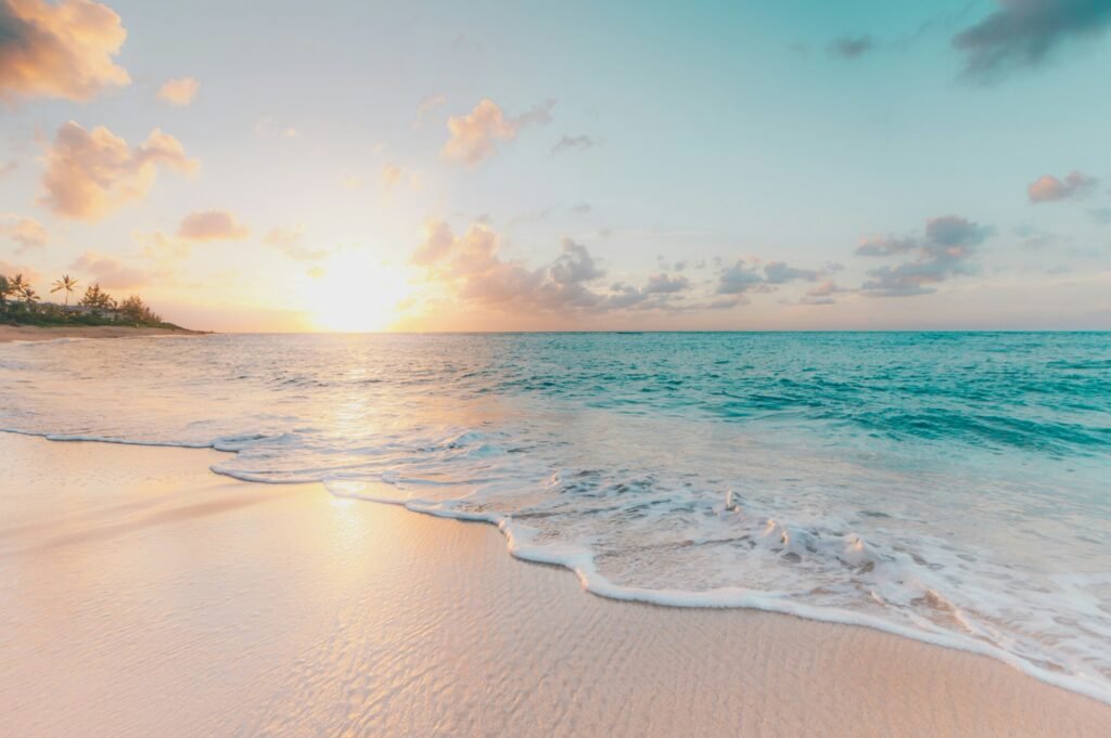 Strand bij zonsondergang met zachte golven